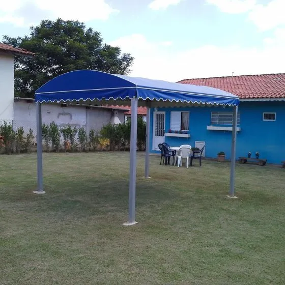 Toldo fixo de lona em pátio de comércio com mesas